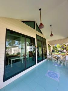 a house with large glass windows and a patio at Chaloklumbay resort2 in Mae Haad