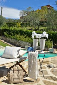 サン・カシャーノ・イン・ヴァル・ディ・ペーザにあるVilla Borri Country Suitesのプールの横に白い花瓶が2本置かれたテーブル