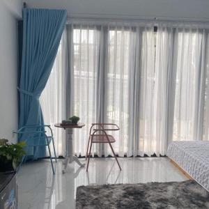 a bedroom with a bed and a chair in front of a window at Jrai Homestay in Pleiku