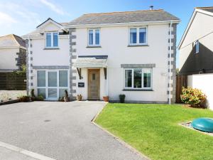 a white house with a driveway at Ridgeback House in Helston