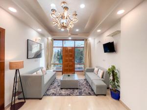 a living room with a couch and a chandelier at The Boutique Stay in Noida