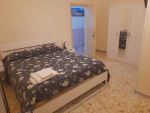 a bedroom with a bed with a black blanket and white towels at B&B Pompeii Airfield in Poggiomarino