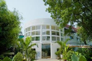 a large white building with trees in front of it at VSR Vriksha Wellness Nature Cure Center in Hyderabad