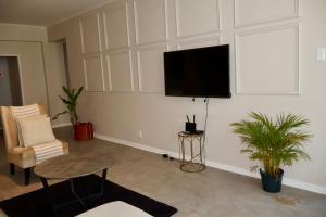 ein Wohnzimmer mit einem Flachbildfernseher an der Wand in der Unterkunft San Remo on Windermere Rd. Humewood Beachfront in Gqeberha + 1 Foto
