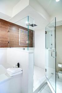 a white bathroom with a shower and a toilet at City Loft Hotel in Beaufort