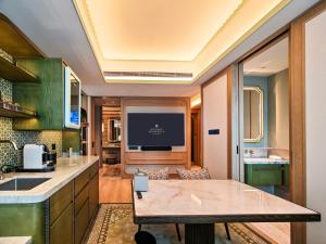 eine Küche und ein Wohnzimmer mit Fernseher in der Unterkunft Shangri-La Kunming in Kunming