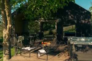 un patio con 2 sillas y una mesa con flores en RELAX HILL Vendégház, en Dunabogdány