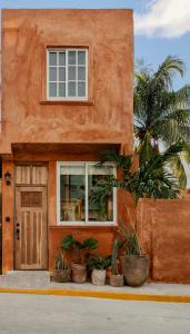 een oranje huis met planten ervoor bij Casa Rocka Boutique Breakfast & Beach Club included in Isla Mujeres