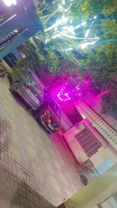 een auto geparkeerd op een parkeerplaats met roze verlichting bij The Modern Home Stay in Guwahati
