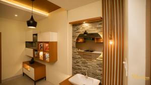 bagno con lavandino e parete in pietra di Spectra Health & Suite a Varkala