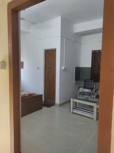 een woonkamer met een stoel en een televisie bij The Modern Home Stay in Guwahati