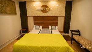 una camera da letto con un letto con una coperta gialla di Spectra Health & Suite a Varkala