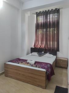 een slaapkamer met een groot bed en een raam bij The Modern Home Stay in Guwahati +5 foto's