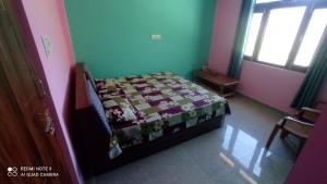 een slaapkamer met een bed met een dekbed erop bij Tanishk Home Stay in Jāmb