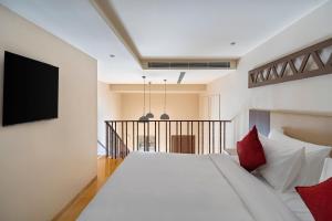 a bedroom with a large white bed with red pillows at Raj Leela Heritage Resort By Estherea in Jāmb +25 photos