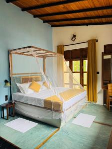 una camera da letto con un grande letto a baldacchino di Sigiriya Traveler's Nest a Sigiriya Altre 26 foto