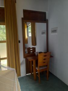 una camera da letto con tavolo, specchio e sedia di Sigiriya Traveler's Nest a Sigiriya