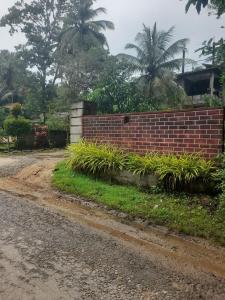 un muro di mattoni sul lato di una strada di Sigiriya Traveler's Nest a Sigiriya