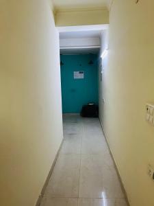 an empty hallway with a blue wall and a tile floor at Hotel Lal in Jāmb