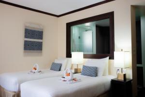 two beds in a hotel room with a mirror at Parasol Blanc in Luang Prabang +64 photos