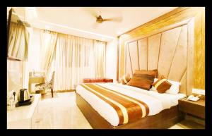 een slaapkamer met een groot bed en een raam bij The CJ Inter National in Amritsar