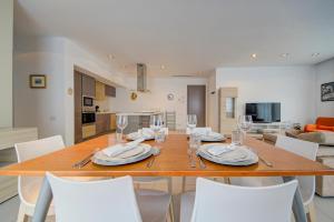 a dining room and living room with a table and chairs at St Julian's 2Br Apartment with Private Jacuzzi in St. Julianʼs