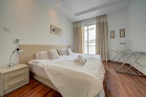 a bedroom with a large bed and a desk at St Julian's 2Br Apartment with Private Jacuzzi in St. Julianʼs
