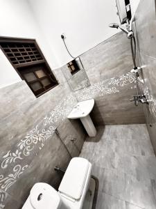 een badkamer met twee toiletten en een wastafel bij Hagiazo Guest Inn Mirissa in Mirissa