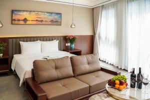 a hotel room with a couch and a bed at Blubiz Hotel 6 in Kon Rung (1)
