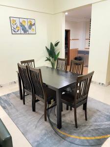 een eettafel en stoelen met een tafel en een plant bij SMC Homestay Cameron Highlands in Cameron Highlands