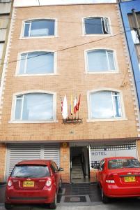 dos coches rojos estacionados frente a un edificio en Hotel Real Estación, en Bogotá