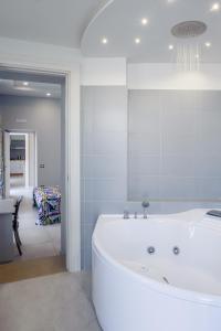 uma banheira branca na casa de banho com uma sala de jantar em Bocca di Bacco em Cimitile