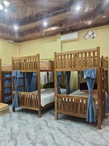 a room with three bunk beds in a room at Sunset Backpackers Hostel in Nongkhiaw
