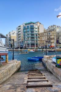 a group of boats in a river with buildings at St Julian's 2Br Apartment with Private Jacuzzi in St. Julianʼs