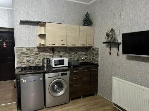 a kitchen with a washing machine and a microwave at Family Studio in Gudauri