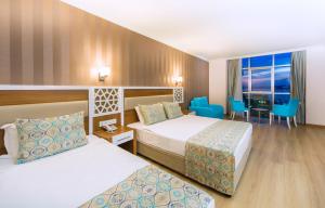 a hotel room with two beds and a desk at Lonicera Resort & Spa Hotel - Ultra All Inclusive in Avsallar +119 photos