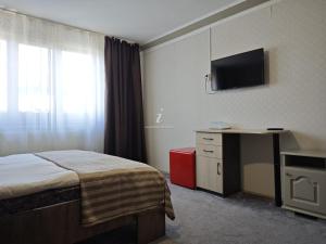 una camera d'albergo con un letto e una televisione di Casa Crăciun a Mănăstirea Humorului