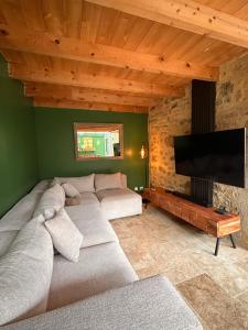 een woonkamer met een bank en een flatscreen-tv bij Gîte de Marcenac in Lalbenque