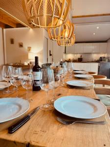 a table with plates and wine glasses on it at Gîte de Marcenac in Lalbenque