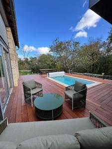 een terras met stoelen en een tafel en een zwembad bij Gîte de Marcenac in Lalbenque