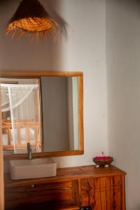 a bathroom with a sink and a mirror at Coconut Mafia Island Bungalows in Utende