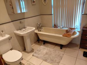 ein Badezimmer mit Badewanne, Toilette und Waschbecken in der Unterkunft Penwortham traditional home in Penwortham