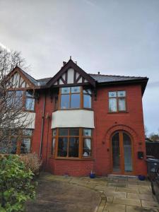ein rotes Backsteinhaus mit einem großen Fenster in der Unterkunft Penwortham traditional home in Penwortham