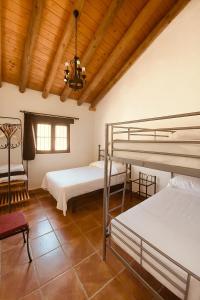 une chambre avec deux lits superposés et un plafond en bois dans l'établissement Casa Rural Privada Arenosos, à Pruna 15 autres photos