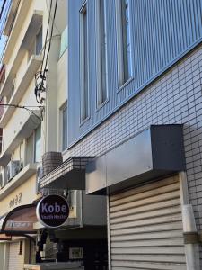een gebouw met een deur en een bord erop bij Kobe Youth Hostel in Kobe