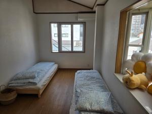 una camera da letto con due letti e una finestra di Kobe Youth Hostel a Kobe
