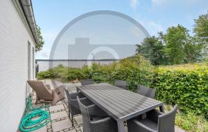 einen Tisch und Stühle auf dem Balkon eines Hauses in der Unterkunft Awesome Home In Kruså With Wifi in Kollund Østerskov