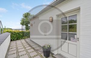 ein Haus mit einer Tür und einer Terrasse in der Unterkunft Awesome Home In Kruså With Wifi in Kollund Østerskov
