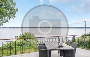 einen Tisch und Stühle auf einem Balkon mit Seeblick in der Unterkunft Awesome Home In Kruså With Wifi in Kollund Østerskov