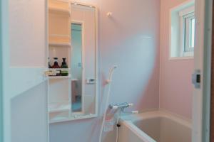 a bathroom with a shower and a tub and a sink at ペコレラ学舎 Teacher House in Yakumo +19 photos